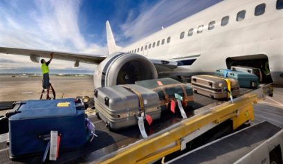 Des bagages passent en soute d'un avion