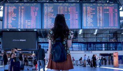 Une personne devant le tableau de départs des avions