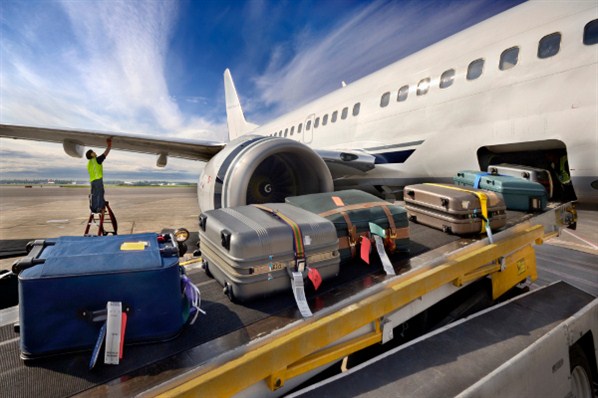 Des bagages passent en soute d'un avion