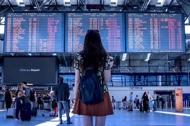 Une personne devant le tableau de départs des avions